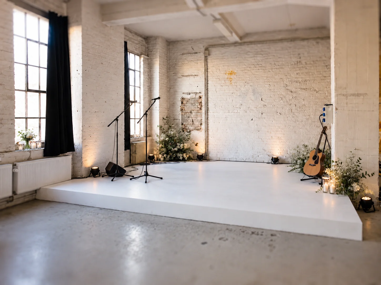 Modernes Loft mit Bühne mit weißer Plattform, Mikrofonen, Gitarre und Industrialdesign in Berlin.